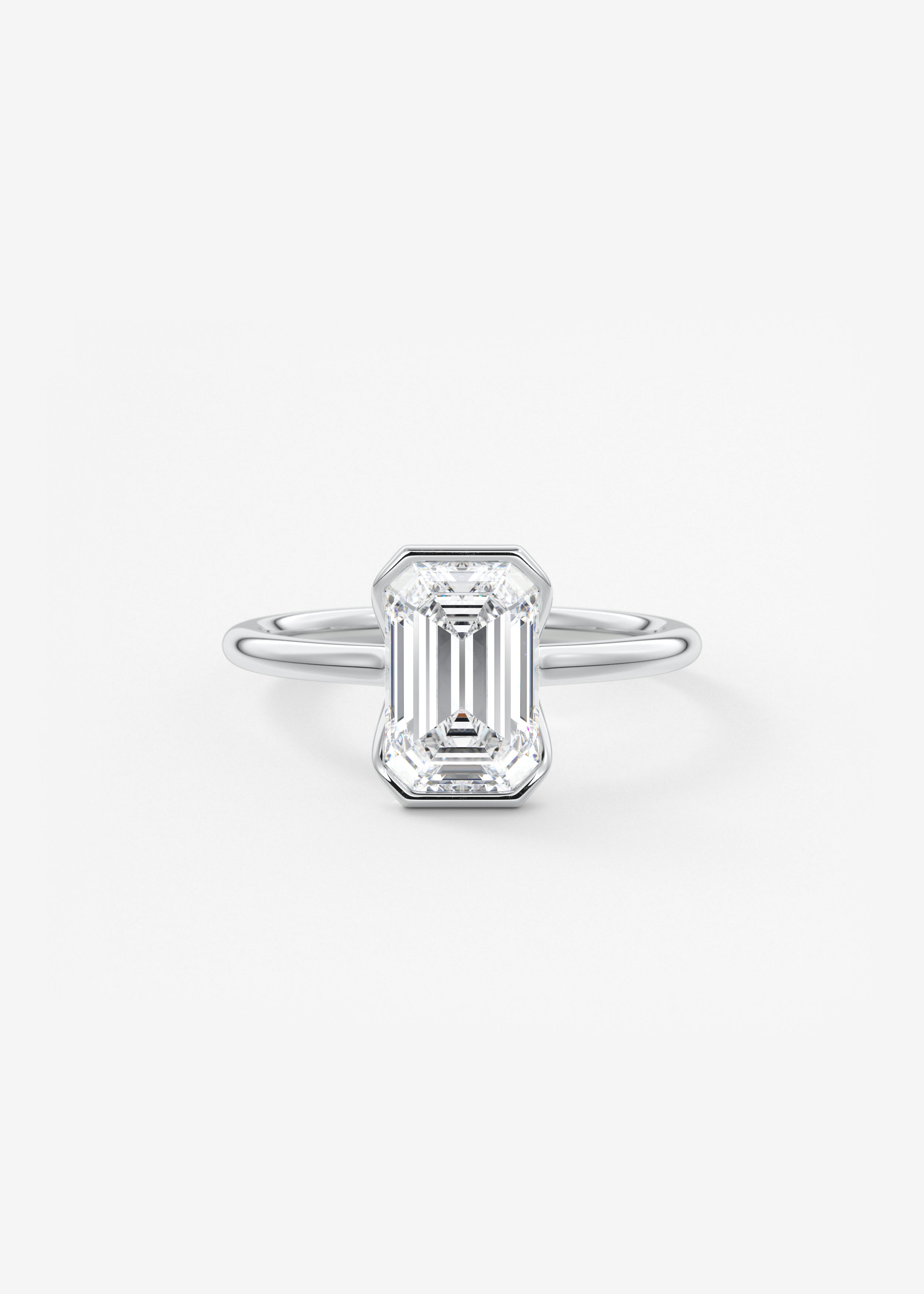 The Clutch  engagement in WG metal featuring Emerald,Radiant cut with Solitaire,Half Bezel setting