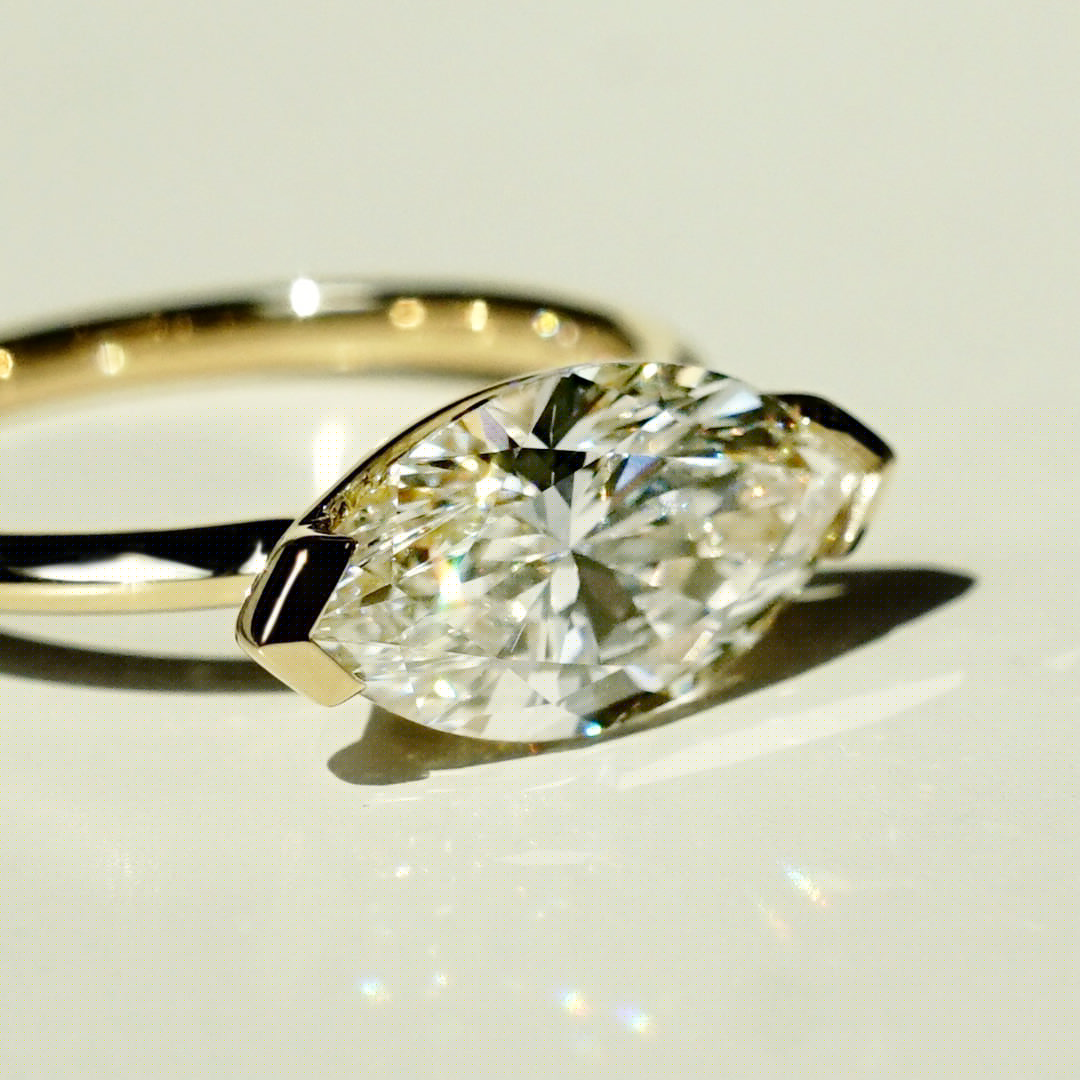 A yellow gold, Marquise diamond engagement lays on its side