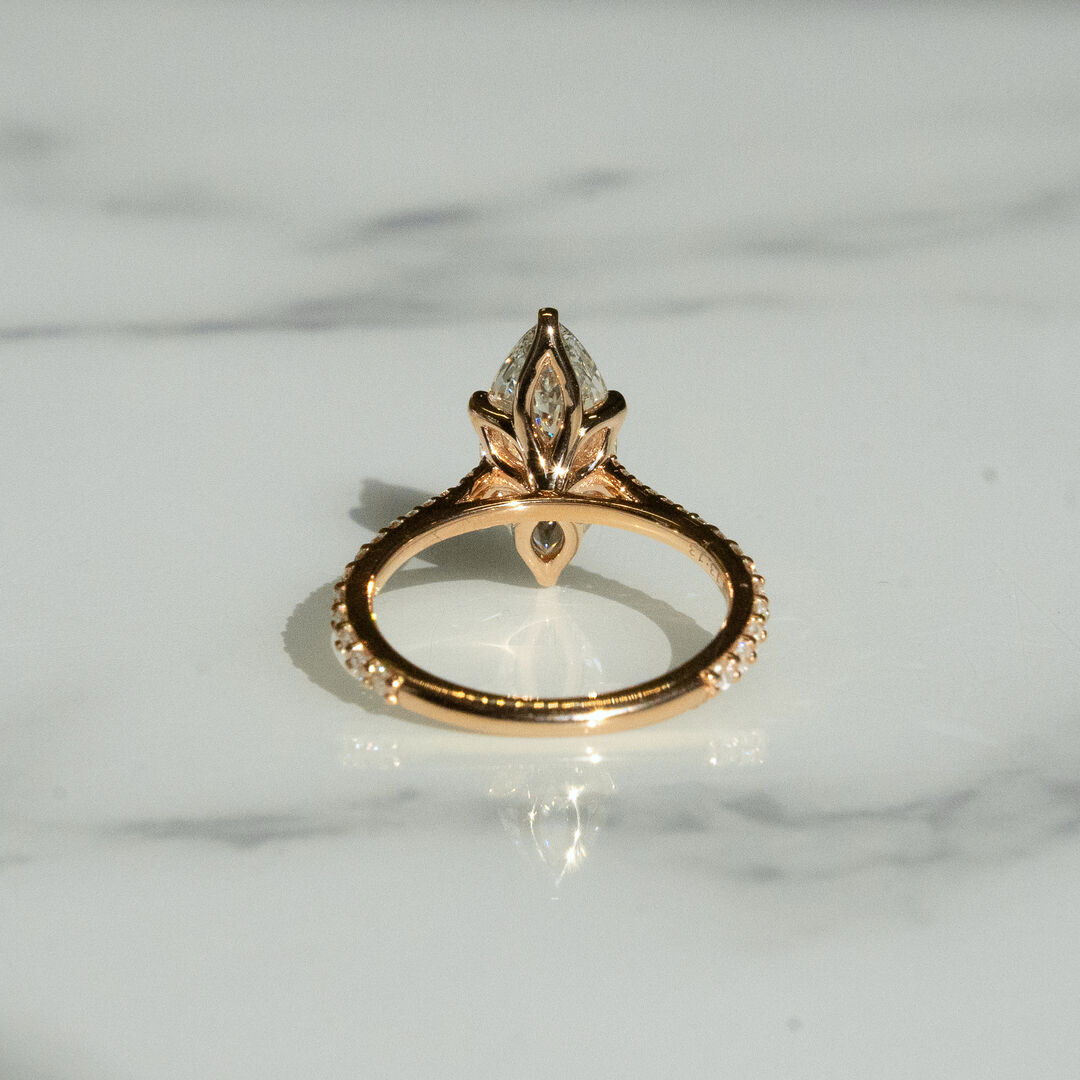 A yellow gold Maquise diamond engagement ring from behind with hidden tulip basket filled with diamonds and pave detail 