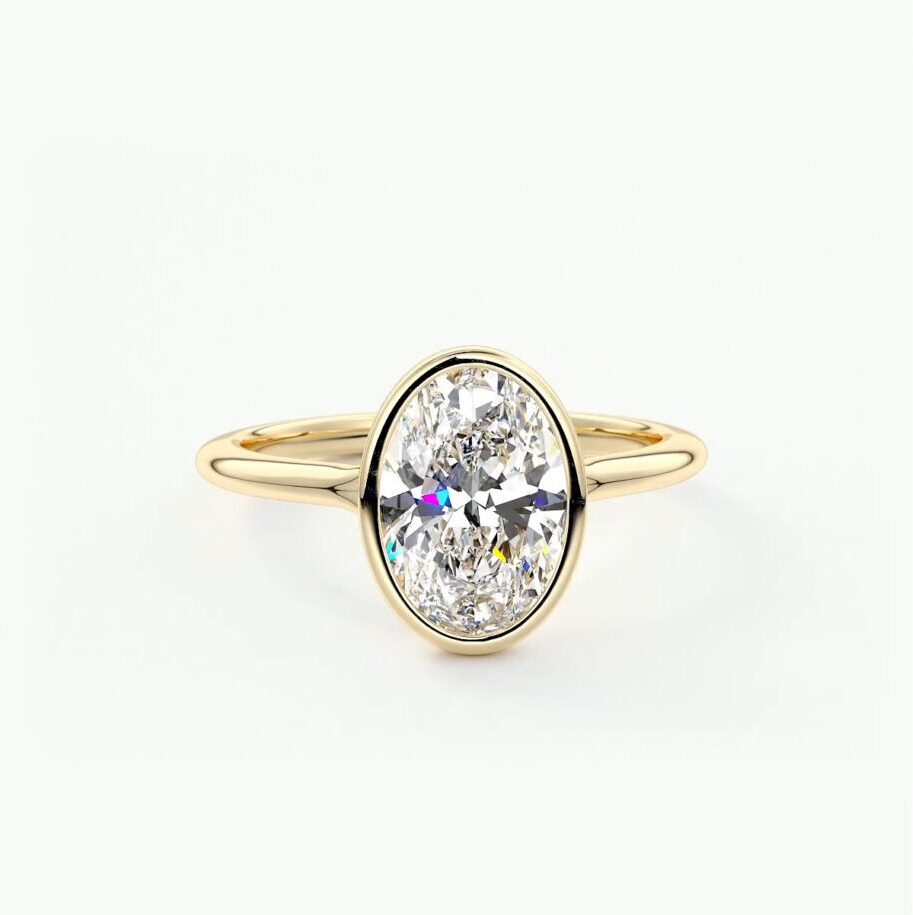 A bezel set oval cut engagement ring in 18k gold 